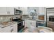Well-equipped kitchen with stainless steel refrigerator, granite countertops, white cabinetry and modern appliances at 5624 62Nd N St, St Petersburg, FL 33709