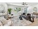 Living room with a gray sofa, white chairs, hardwood floors, and a window at 5624 62Nd N St, St Petersburg, FL 33709