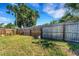 Large backyard enclosed by wood fence with plenty of space and a view of neighborhood greenery at 5711 9Th N Ave, St Petersburg, FL 33710