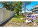 Fenced backyard with a lawnmower, a stack of boxes, and view to a green lot at 577 Waterfall Dr, Spring Hill, FL 34608