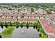 A beautiful aerial view of townhomes with red tile roofs nestled around a serene pond with a water fountain at 601 52Nd Ter N, St Petersburg, FL 33703