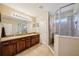 Bright bathroom with double sink vanity, granite countertops, and glass enclosed shower at 601 52Nd Ter N, St Petersburg, FL 33703