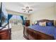 Relaxing bedroom with a large window, plush blue bedding, and dark wood furniture bathed in natural light at 601 52Nd Ter N, St Petersburg, FL 33703