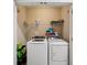 Compact laundry room featuring a new washer and dryer with overhead storage at 601 52Nd Ter N, St Petersburg, FL 33703