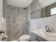 Bathroom features a standing shower with gray marbled tile and gray cabinets at 6403 N Lois Ave, Tampa, FL 33614