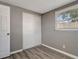 Bedroom with gray walls, vinyl flooring, and a closet with sliding doors at 6403 N Lois Ave, Tampa, FL 33614