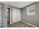 Bedroom with gray walls, wood-look flooring, and double door closet at 6403 N Lois Ave, Tampa, FL 33614