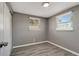 Bedroom featuring two windows, modern lighting, and wood-look floors at 6403 N Lois Ave, Tampa, FL 33614