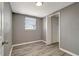 Bedroom features a window and closet with gray walls and wood-look floors at 6403 N Lois Ave, Tampa, FL 33614