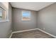 A sunlit bedroom with wood-look flooring and neutral gray walls at 6403 N Lois Ave, Tampa, FL 33614