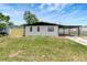 Charming single-story home featuring a carport and a well-maintained front lawn at 6403 N Lois Ave, Tampa, FL 33614