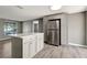 Kitchen features a refrigerator and island with gray cabinetry and light countertops at 6403 N Lois Ave, Tampa, FL 33614