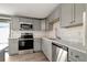 Well-lit kitchen features stainless steel appliances, gray cabinetry, and light countertops at 6403 N Lois Ave, Tampa, FL 33614