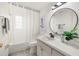 Bright bathroom featuring a shower-tub combo, round mirror, and neutral-toned decor at 6433 Reef Cir, Tampa, FL 33625