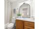 Bathroom features a wooden vanity, a mirror, and a shower with a neutral-colored shower curtain at 6433 Reef Cir, Tampa, FL 33625