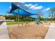 A vibrant playground with swings, slides, and climbing structures, shaded by a blue canopy for sunny days at 6433 Reef Cir, Tampa, FL 33625