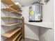 Storage area featuring wooden shelves, water heater, and clean organized space at 6433 Reef Cir, Tampa, FL 33625