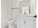 Bathroom features a white vanity with a modern faucet, toilet and shower with black hardware at 7304 Donnybrook Ln, Sarasota, FL 34240