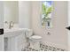 Powder bathroom featuring a pedestal sink and a view of the neighborhood through a window at 7304 Donnybrook Ln, Sarasota, FL 34240