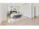 Airy bedroom with light wood floors, neutral decor, and a decorative bench at 7304 Donnybrook Ln, Sarasota, FL 34240