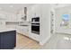 Modern kitchen with white cabinets, stainless steel appliances, and light wood floors at 7304 Donnybrook Ln, Sarasota, FL 34240