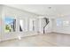 Bright living room with large windows, a staircase, and light wood flooring at 7304 Donnybrook Ln, Sarasota, FL 34240