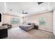 Spacious bedroom with tray ceiling, carpet flooring, large windows, and ceiling fan at 8016 Rock Spring Ct, Land O Lakes, FL 34638