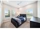 A cozy bedroom features a dark wood bed frame and three windows providing natural light at 8016 Rock Spring Ct, Land O Lakes, FL 34638