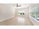 Bright bedroom with neutral walls, tile flooring, ceiling fan, and large windows providing ample natural light and outdoor views at 8016 Rock Spring Ct, Land O Lakes, FL 34638