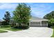 Charming single-story home features a well-manicured lawn, mature landscaping, and a long driveway leading to a three-car garage at 8016 Rock Spring Ct, Land O Lakes, FL 34638