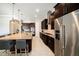 A modern kitchen features dark wood cabinets, stainless steel appliances, and a large island with granite countertops at 8016 Rock Spring Ct, Land O Lakes, FL 34638