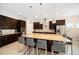 Well-equipped kitchen with a large island, stainless steel appliances, dark wood cabinets, and pendant lighting at 8016 Rock Spring Ct, Land O Lakes, FL 34638