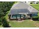 Aerial view of a sparkling pool with a screen enclosure, lounge area, and lush backyard landscaping at 8016 Rock Spring Ct, Land O Lakes, FL 34638
