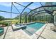 Enclosed pool and hot tub with brick patio and view of the greenery that surrounds the property at 8016 Rock Spring Ct, Land O Lakes, FL 34638