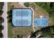 Aerial view of tennis and basketball courts, with parking and green spaces nearby at 8016 Rock Spring Ct, Land O Lakes, FL 34638