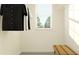Bright closet with hanging storage and a bench, illuminated by natural light from a window at 8778 Linked Dr, New Port Richey, FL 34655