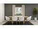 Modern dining room with neutral color palette, stylish seating, and view of manicured landscaping provides comfortable entertaining at 8778 Linked Dr, New Port Richey, FL 34655