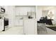 Modern kitchen features stainless steel appliances, sleek white cabinetry, and bar stool seating, blending functionality and style at 8778 Linked Dr, New Port Richey, FL 34655
