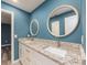 This modern bathroom features double sinks, granite counter top, and a round mirror at 9292 120Th Ln, Seminole, FL 33772