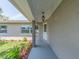 View of the home's facade, showing front door, decorative landscaping, and overhead lighting at 9292 120Th Ln, Seminole, FL 33772