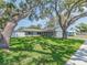 Well-maintained front yard with lush green grass and mature trees, creating a welcoming curb appeal at 9292 120Th Ln, Seminole, FL 33772
