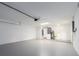 A spacious garage with painted walls and floors, featuring a water heater and utility sink at 9292 120Th Ln, Seminole, FL 33772