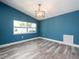 Cozy living room is freshly painted with modern light fixture and gray tone flooring at 9292 120Th Ln, Seminole, FL 33772