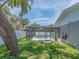 Backyard pool offers a screened-in area, surrounded by lush greenery and providing privacy at 9292 120Th Ln, Seminole, FL 33772