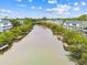Aerial view of the community featuring multiple docks along the canal, mature landscaping, and bright skies at 9812 Indian Key Trl # 84, Seminole, FL 33776