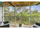 Screened-in balcony with wicker chairs and lush tropical greenery view at 9812 Indian Key Trl # 84, Seminole, FL 33776