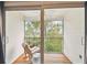Relaxing screened balcony with a rocking chair and views of lush greenery at 9812 Indian Key Trl # 84, Seminole, FL 33776