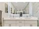 Sleek bathroom boasting an illuminated mirror, double sinks, and modern tiling at 9812 Indian Key Trl # 84, Seminole, FL 33776