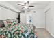 Cozy bedroom with floral bedding, a ceiling fan, carpet flooring, and an open doorway to another room at 9812 Indian Key Trl # 84, Seminole, FL 33776