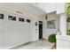 Close-up of townhome entrance with garage, door, modern light, painting, and welcome sign enhancing curb appeal at 9812 Indian Key Trl # 84, Seminole, FL 33776